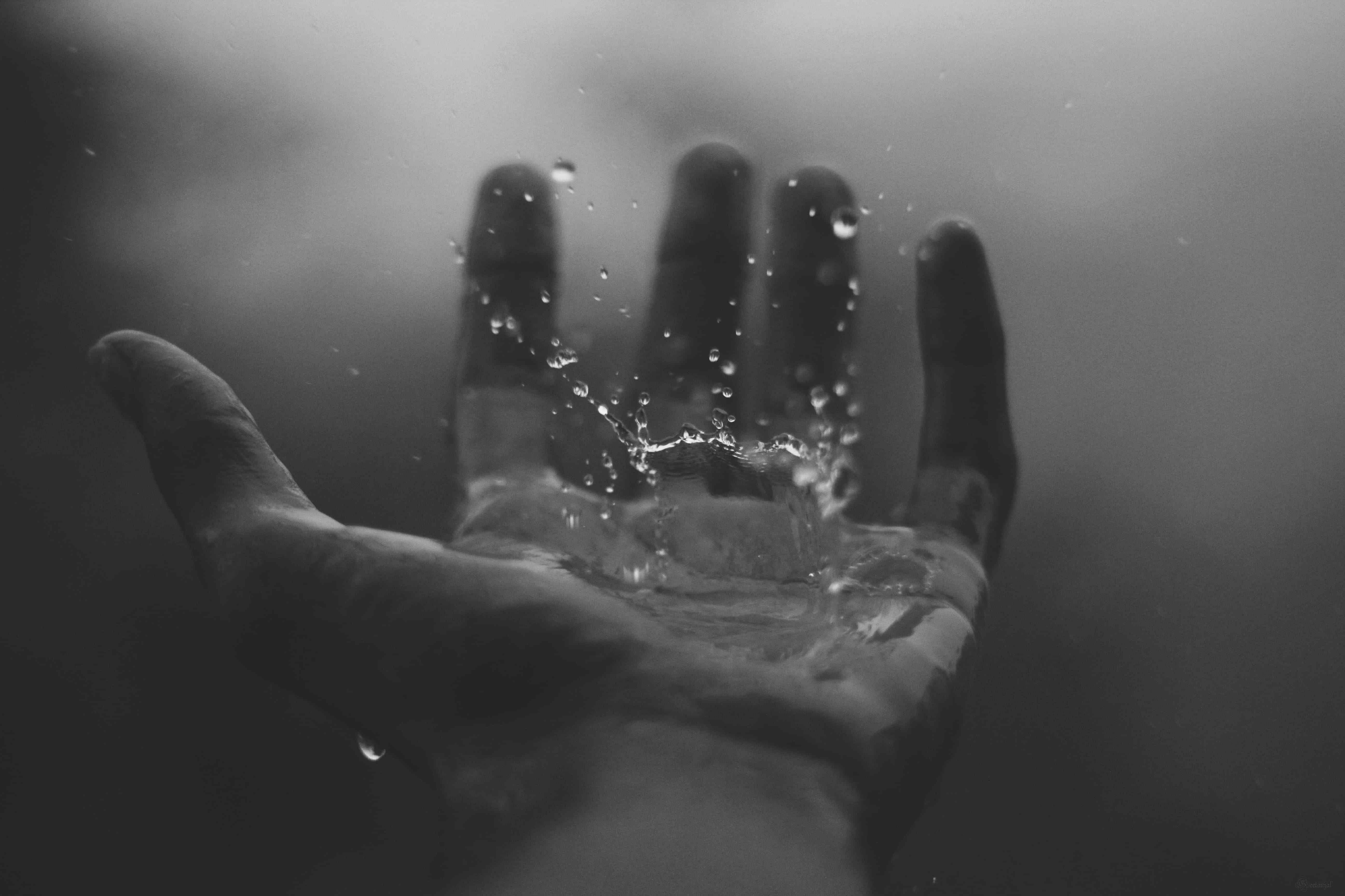 Person catching rain water on his hand